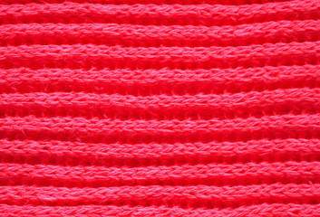 Knitted fabric texture. Red color. English knitting with front and back loops. Knitting on the knitting needles. Horizontal lines