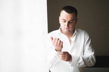 Beautiful man, groom posing and preparing for wedding