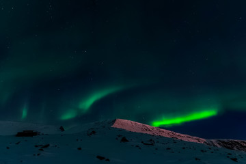 Aurora borealis in night northern sky. Ionization of air particl