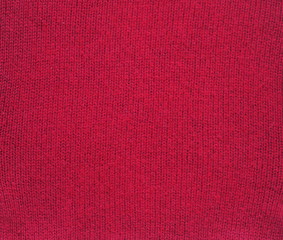 Knitted fabric texture. Red color. Garter stitch with facial loops. Knitting on the knitting needles. Knitted background.