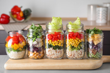 Glass jars with healthy meal on light grey table