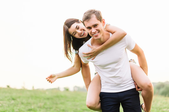 Young couple in love hugging on grass field. Walking along grass field.