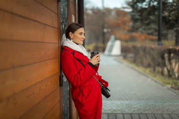 young woman on a walk with cappuccino coffee