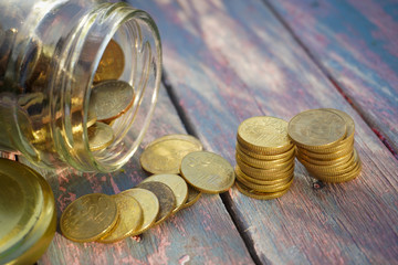 Saving conceptual. Gold coins pile and stacked on the wooden with natural background.