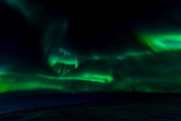 Aurora borealis in night northern sky. Ionization of air particl