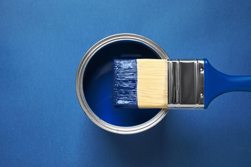 Can of paint and brush on bright background, top view. Color of the year 2020 (Classic blue)