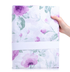 Purple pattern flower folded duvet cover in hand on white background isolation