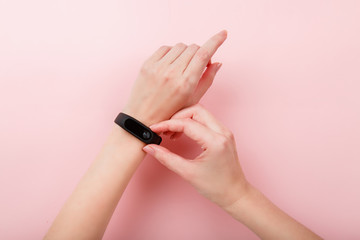 Woman checks the readings on the Smart Band Sport bracelet. Fitness band run tracker on girl's hand. wristband with running activity steps counter and heartbeat pulse meter