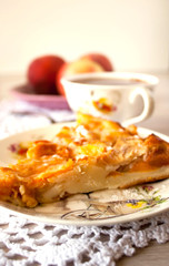 Homemade fruit apple apricot peach pie on white crochet napkin on white rustic table background