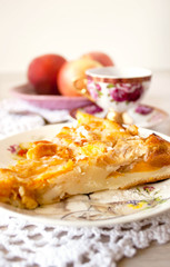 Homemade fruit apple apricot peach pie on white crochet napkin on white rustic table background