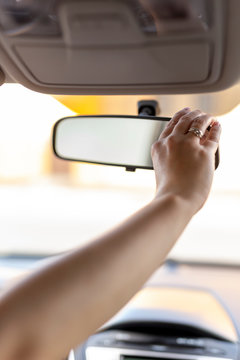 Woman Adjusting Rearview Mirror In The Car