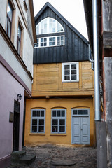 Beautiful and interesting yellow home with black style roof in a small local street.