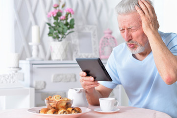 Portrait of a senior man using tablet