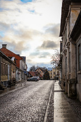 Cloudy countryside city cityscape view with brick road street.