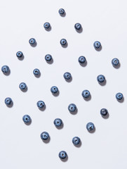 pattern of fresh blueberries is laid out on a white background