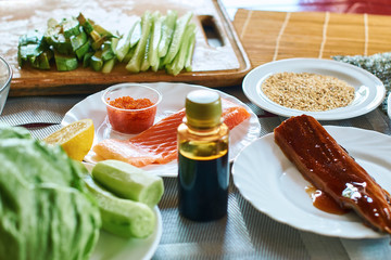 Homemade sushi rolls preparation. Traditional ingredients products foodstuff on the home kitchen table ready to be prepared. Asian food background.