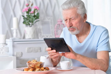 Portrait of a senior man using tablet