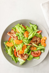 Salad with sweet tangerines and pieces of pork