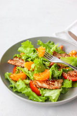 Salad with sweet tangerines and pieces of pork