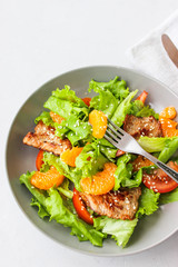 Salad with sweet tangerines and pieces of pork