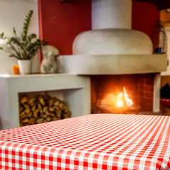 Table background of free space and blurred home interior with fireplace 