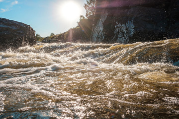 sunlight and glare on mountain streams of water, foaming rapids on the river