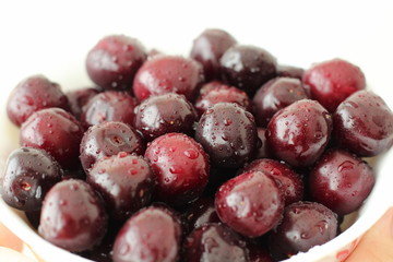 Full plate of fresh cherries berries covered with drops of water.