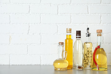 Different cooking oils on grey table. Space for text