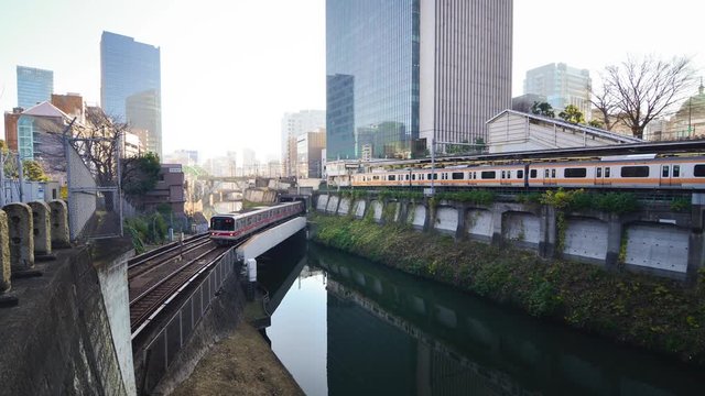 Train passing on the bridge in the Tokyo city across the bridge and city view in the background.Tokyo's train/subway train moving in city center of Tokyo.Tokyo Olympic 2020 4K UHD video transportation