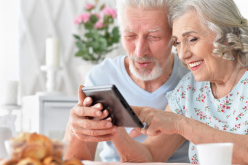 portrait of happy beautiful senior couple using tablet