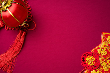 Chinese New Year decorations with red background with assorted festival decorations. Chinese characters means abundant of wealth, prosperity and luck. Flat lay.