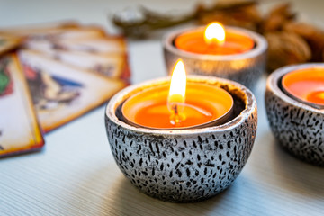 Tarot cards with red candles on a white wooden table background