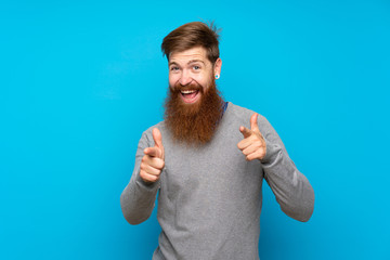 Redhead man with long beard over isolated blue background pointing to the front and smiling