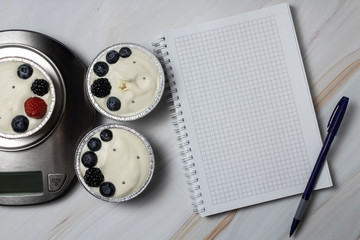 Cheesecake is on the scales. Cheesecake with strawberries and blueberries. Cheesecake in aluminum