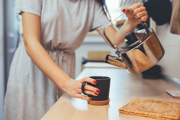 Fototapeta na wymiar woman in kitchen drinking coffee or tea