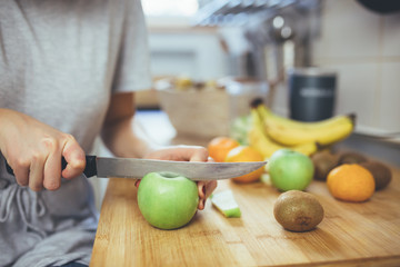 woman preparing fruit smoothie in her kitchen