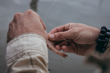 Hand attaching Shrimp Bait onto Fishing Hook