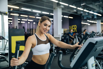 young beautiful girl doing exercises in the gym, jogging on the track indoors, fitness and crossfit