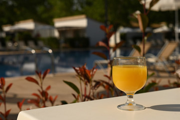 glass of orange juice in a poolside restaurant, food concept