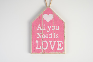 Wooden plank pink with an inscription on a white background for Valentine's Day, wedding, birthday and other holidays, view from the top.