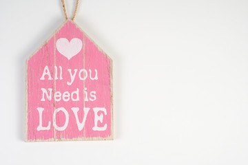 Wooden plank pink with an inscription on a white background for Valentine's Day, wedding, birthday and other holidays, view from the top.