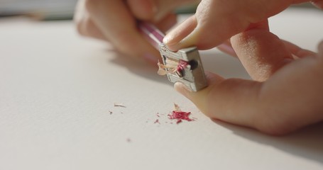 Girl sharpening colored pencils	