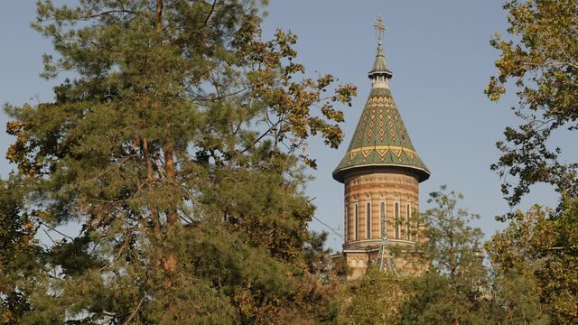 Cupola of Orthodox Metropolitan Cathedral Timisoara between tree crowns 4K footage
