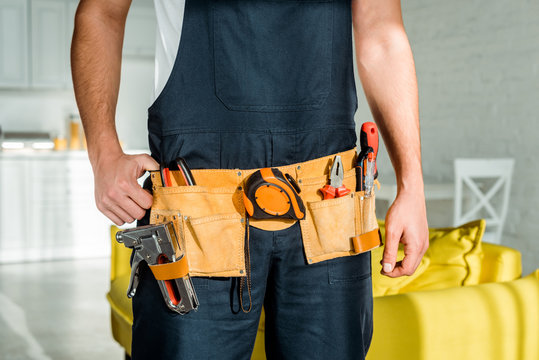 cropped view of installer standing and touching tool belt