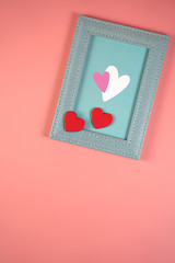 Blue frame with hearts on a pink background, concept for Valentine's Day, wedding, birthday and other holidays, view from the top.