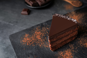 Delicious chocolate cake on grey table, space for text
