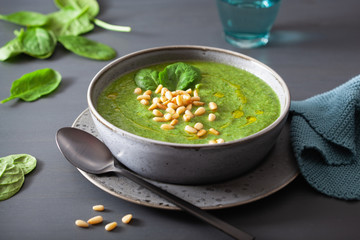 green creamy cauliflower spinach soup on gray background