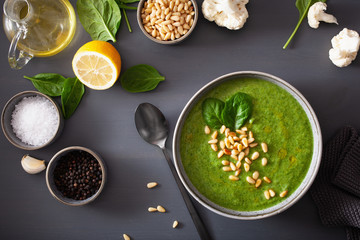 green creamy cauliflower spinach soup on gray background