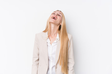 Young business blonde woman on white background relaxed and happy laughing, neck stretched showing teeth.