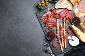 Tasty prosciutto served on grey table, flat lay. Space for text